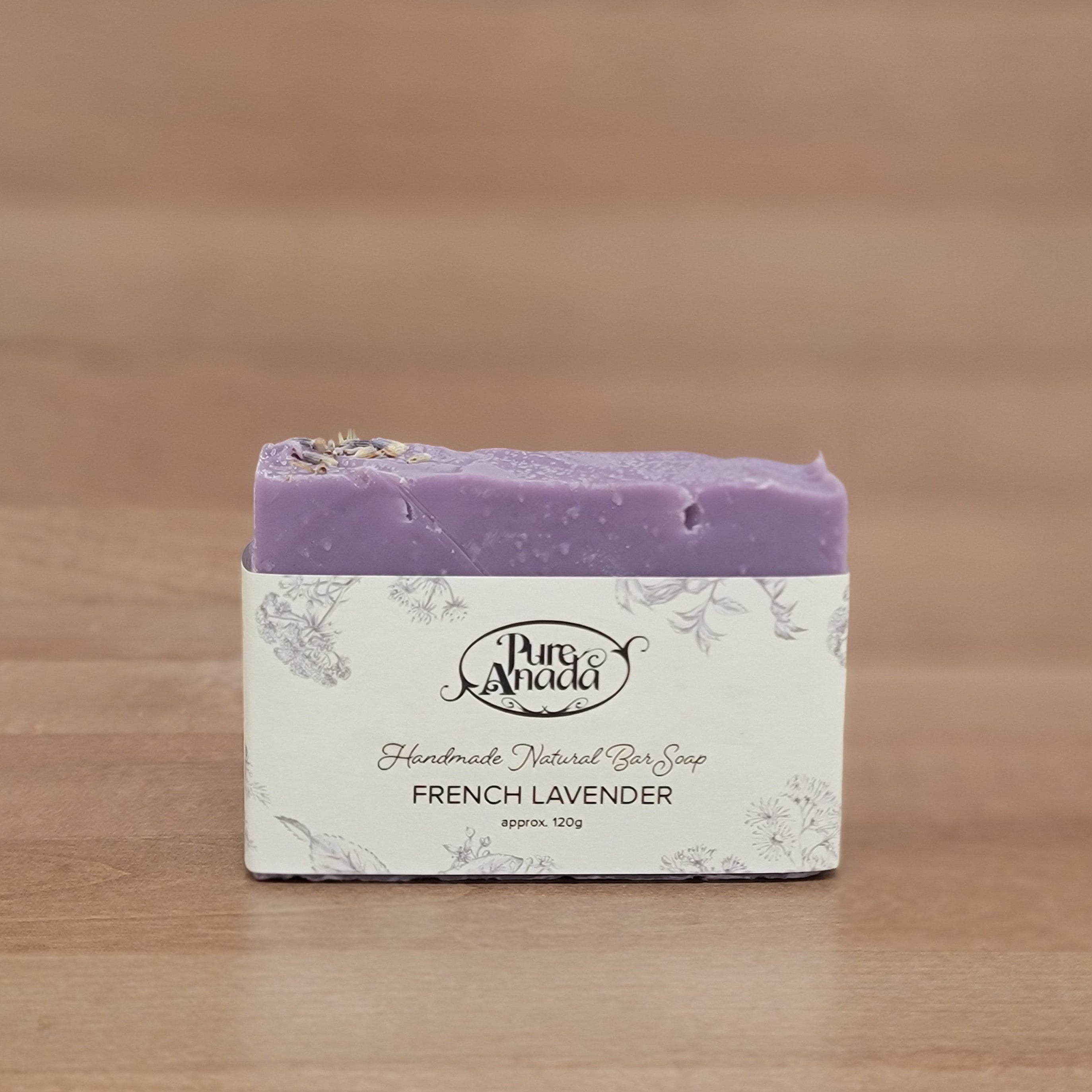 Bar of soap with a purple label on a wooden surface
